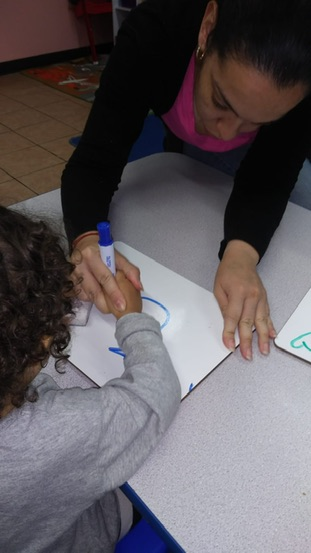Angela Velez,a NYSCAS alumna, is pictured working with a student in her Bronx classroom.