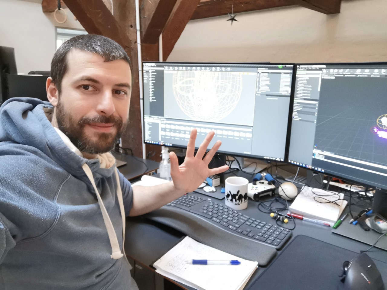 VIdeo game designer and NYSCAS alumnus Mikhail Akopyan is pictured at his desk with two screens.