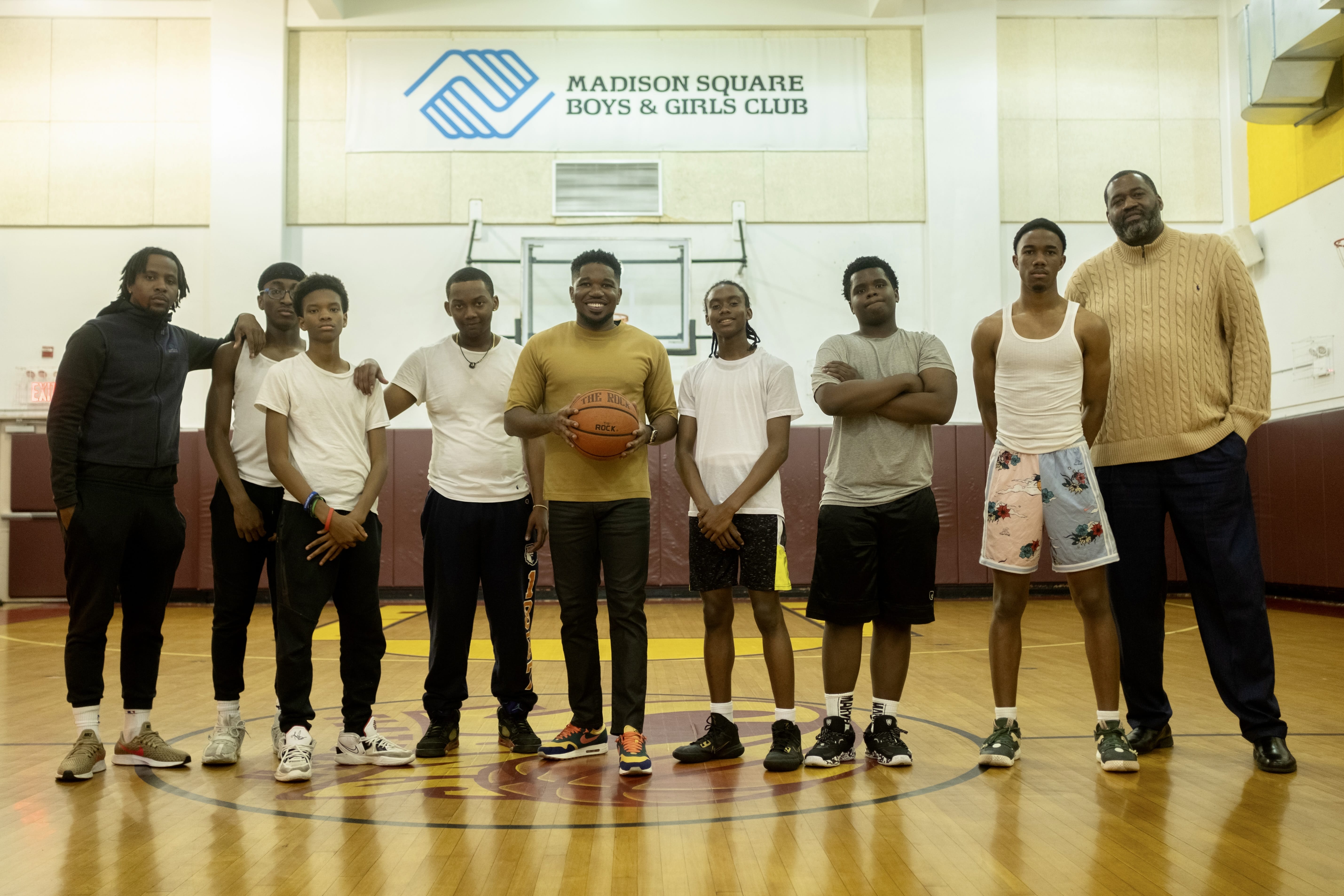 Jade Daniels with a group of kids in the basketball court of the Madison Square Boys and Girls club