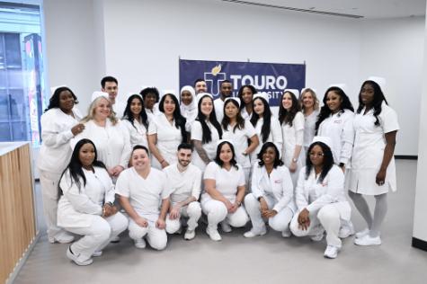 The 23 members of NYSCAS' first graduating class of nurses pose for a photo all in white nursing scrubs, as is traditional for nursing graduation pinning ceremonies. Five males and 18 females now have the Associate of Science in Nursing and are ready to take their RN licensing exams.