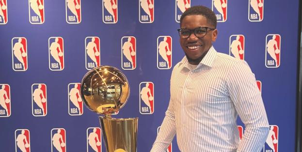 Jade Daniels standing next to trophy with NBA logo in background