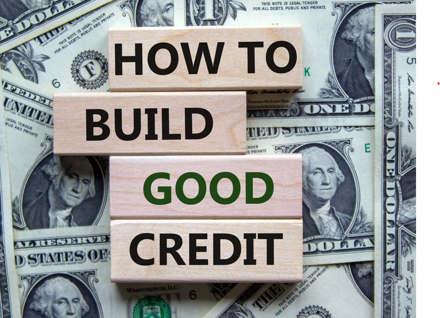 Sign that says "How to Build Good Credit" over a background of dollar bills.