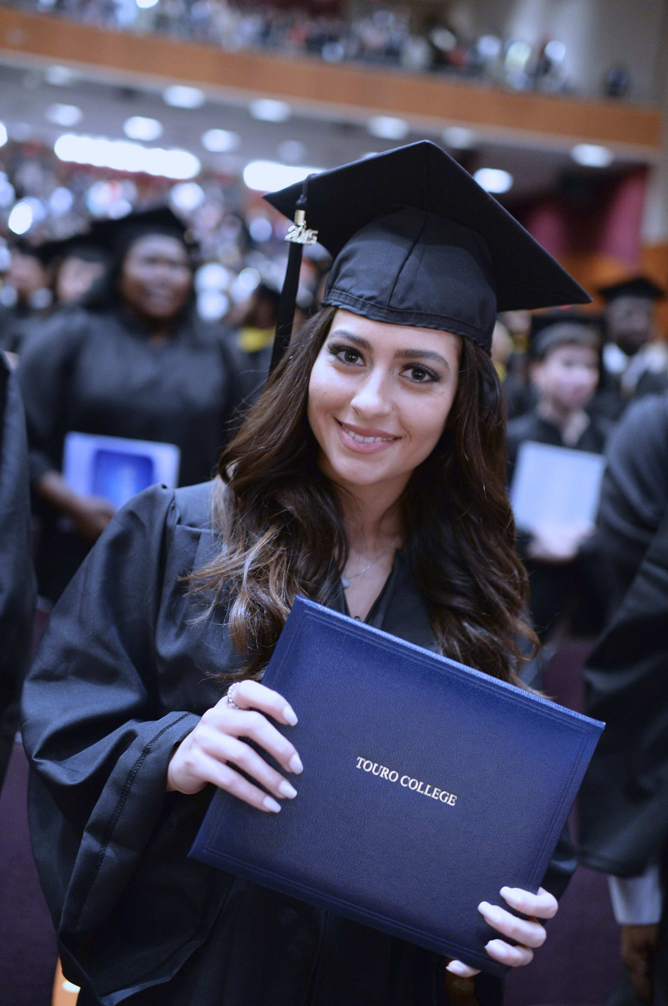 Class of 2015 graduate of NYSCAS\'s Brooklyn division proudly displays her Touro College diploma